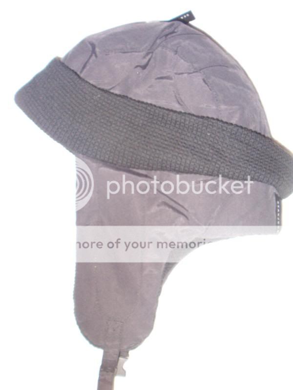 Bomber style hat features earflaps with an adjustable buckle below 